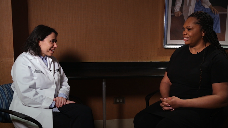 Dr. Dina Podolsky and Shanise Mulrain sit across from each other in a conference room.