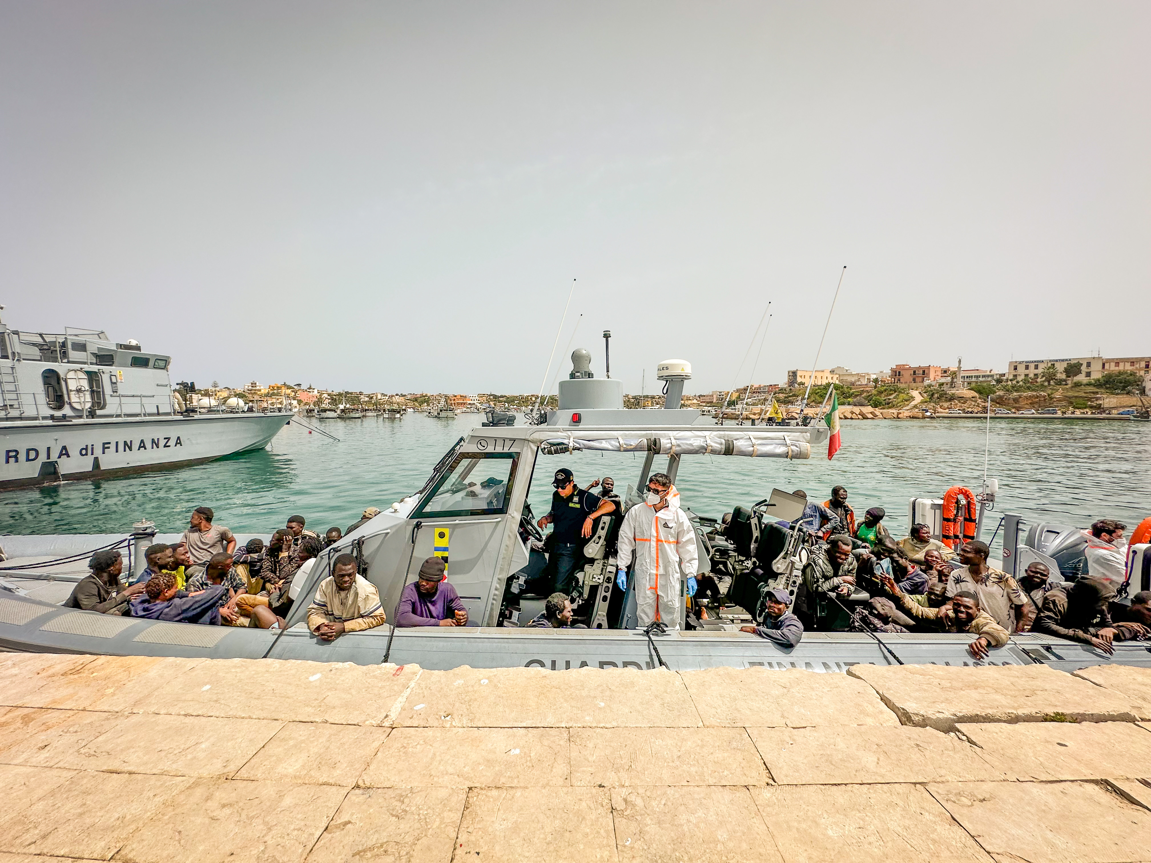 Health workers help arriving migrants in Lampedusa