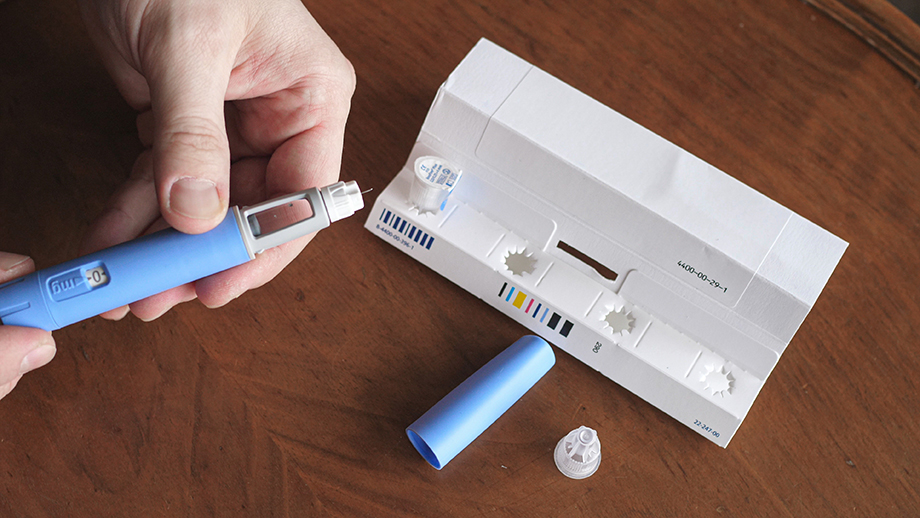 Photograph of a man’s hands as he prepares a Semaglutide Ozempic injection to control blood sugar levels.