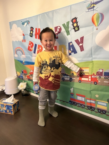 nate stands in front of a birthday banner.